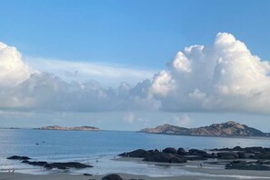 A beach with rocks and a distant island. - Yinghaiju Hotel, Weizhou Island (Putian)