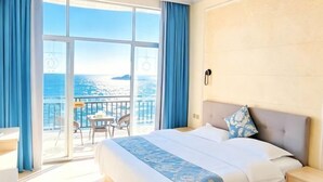 A hotel room with a large window, a bed, a bedside table, and a view of the sea. - Yinghaiju Hotel, Weizhou Island (Putian)