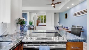 A modern kitchen with a central island, a ceiling fan, and pendant lighting. - Gorgeous Renovated Condo Walking Distance to Beaches!! Large Private Lanai (Kihei)