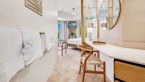 A modern bathroom with a large mirror, a wooden chair, and a glass shelf. - Gorgeous Renovated Condo Walking Distance to Beaches!! Large Private Lanai (Kihei)