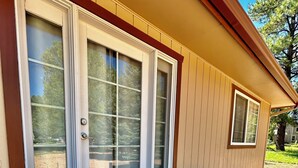 A house with a front porch, a sliding glass door, and a small window.
