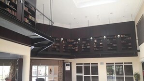Een ruime lobby met een hoge plafond, een trap en een uitgebreid boekenkastgedeelte.
