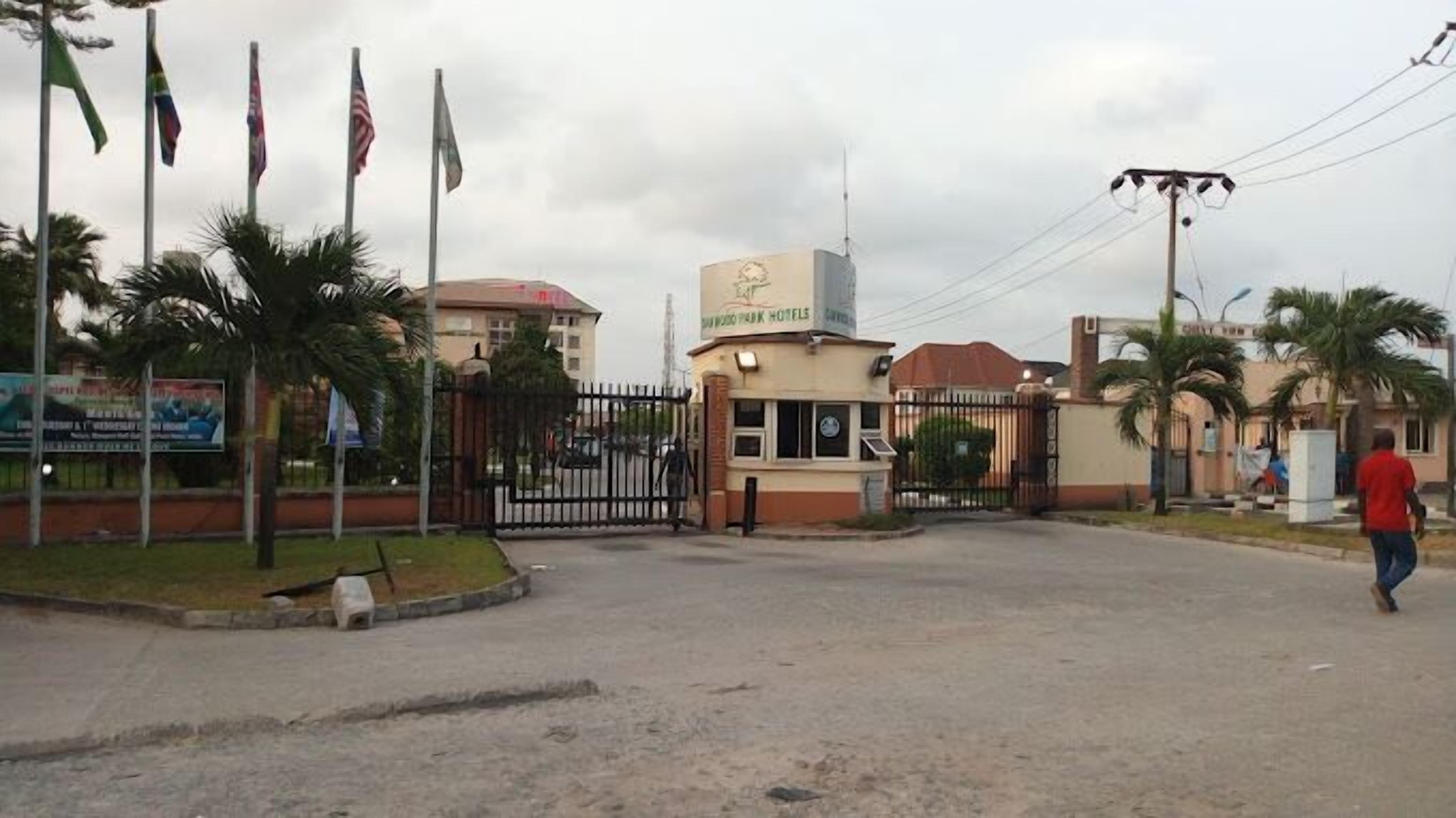 Una entrada con puerta de reja a un hotel, con un letrero que dice "BUDDY PARK HOTELS".