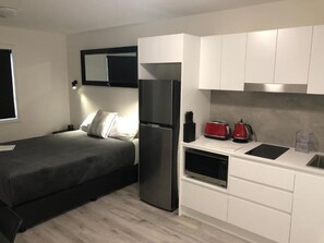 Una cocina compacta con refrigerador, microondas y tostadora.