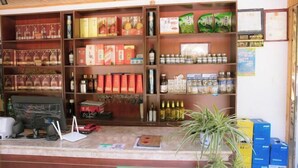 Una tienda con estantes llenos de diversos productos, incluyendo alimentos envasados, botellas y cajas.