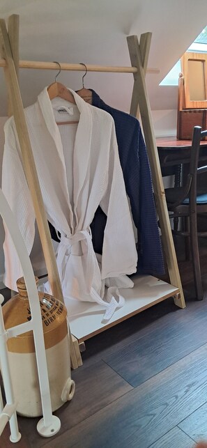 A wooden rack with a white robe and a blue robe hanging on it. - The Stables - Charming cottage in beautiful West Cork (Skibbereen)