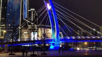 A nighttime view of a bridge with illuminated cables and a modern structure.