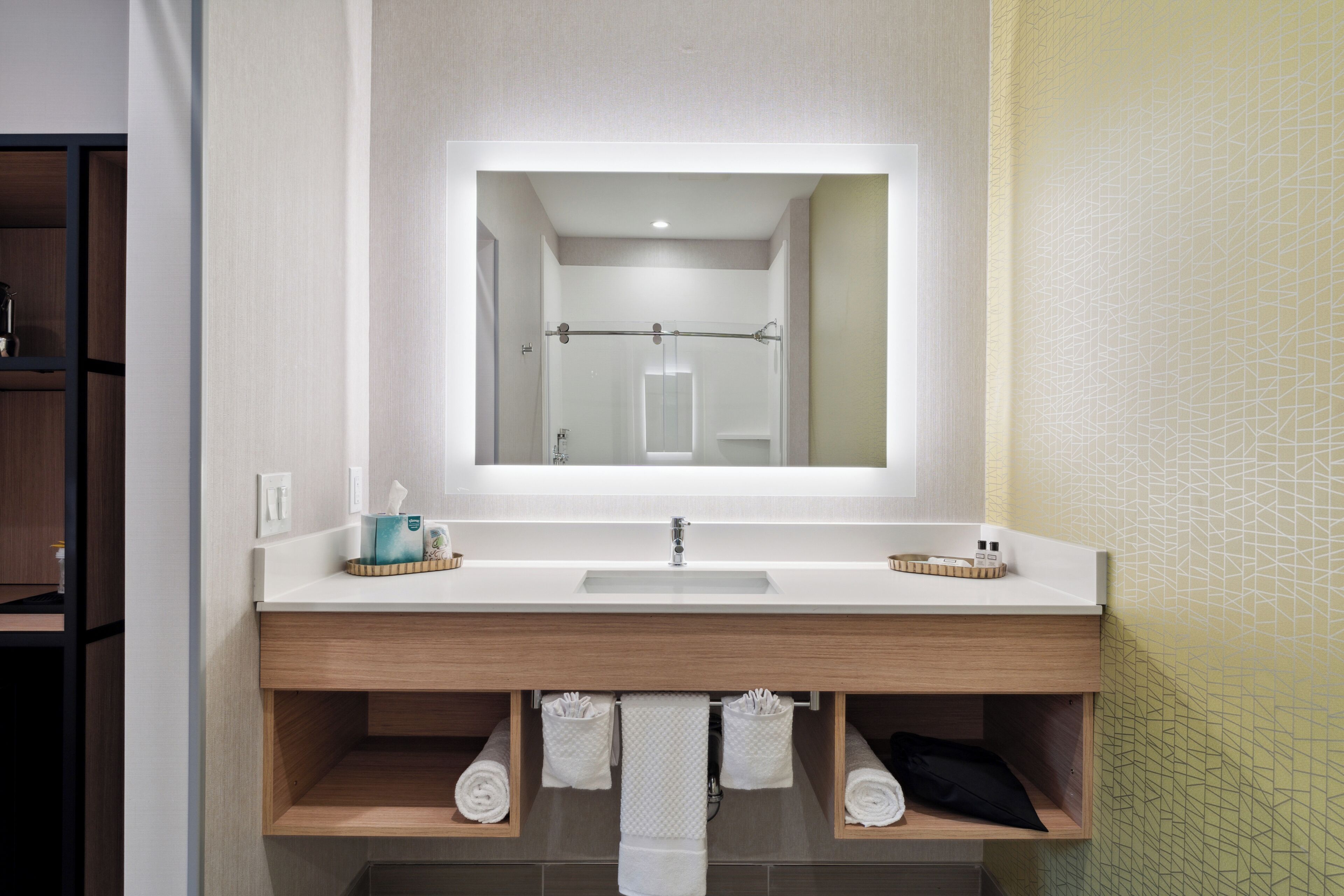 Ein modernes Badezimmer mit einem großen Spiegel, zwei Waschbecken und Holzböden darunter.