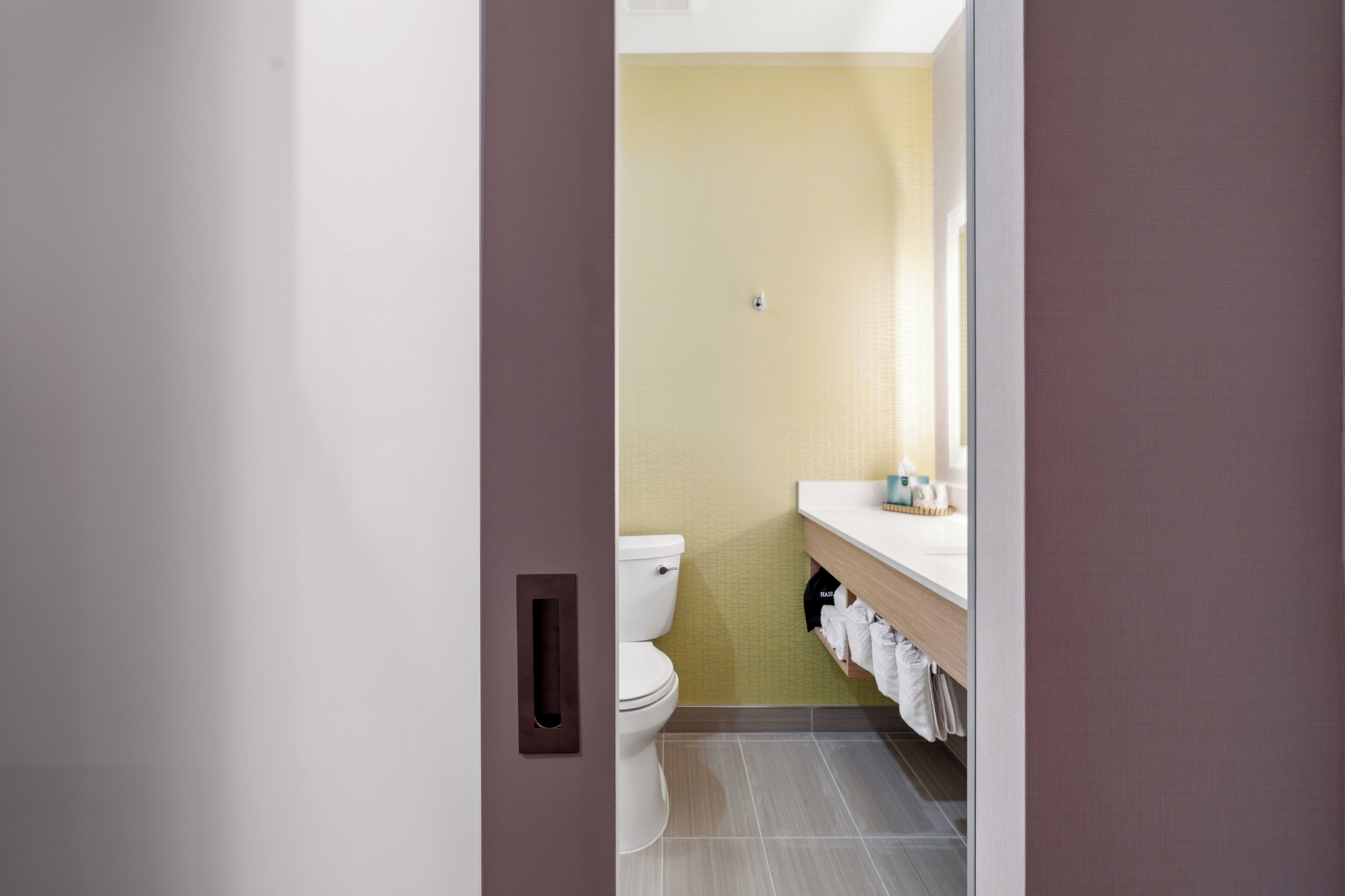 A bathroom with a toilet, a sink, and a mirror.