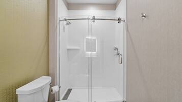 A modern bathroom with a glass-enclosed shower, a toilet, and a sink.