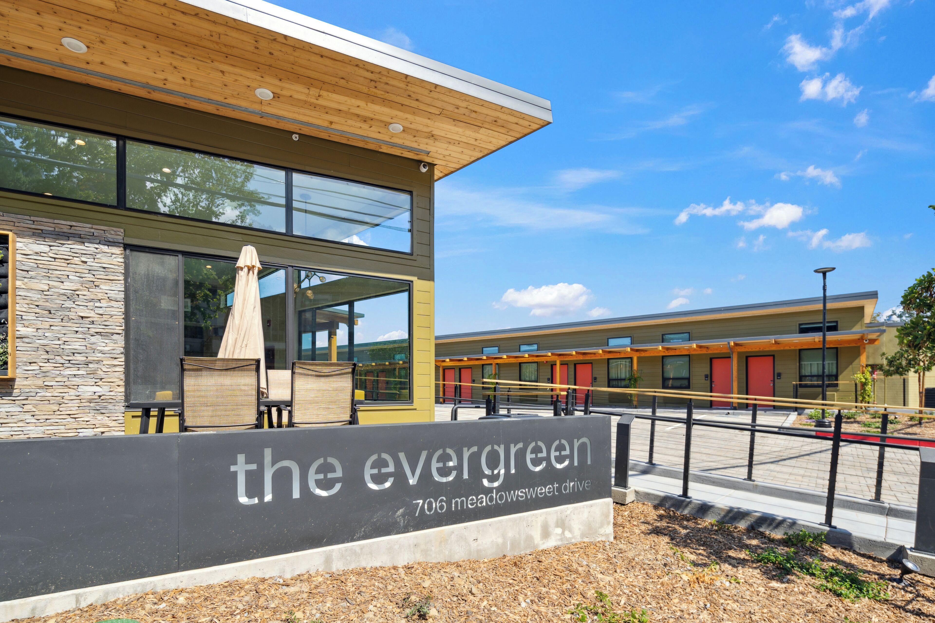 Un edificio moderno con un letrero que dice “the evergreen 706 meadowsweet drive”.