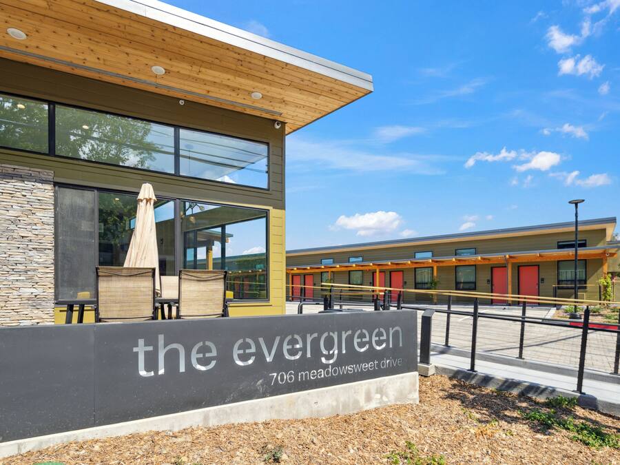 Un edificio moderno con un letrero que dice “the evergreen 706 meadowsweet drive”.