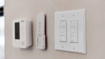 A wall-mounted thermostat and control panel with multiple settings.