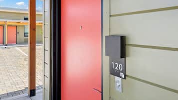 A hotel entrance with a red door, a number sign '120', and a small mailbox.