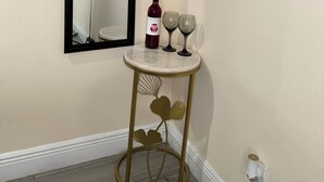 A corner with a round table, a wine bottle, and two wine glasses on a white wall. - Welcome to our charming studio, perfectly located near Tampa Bay's attractions. (Tampa)