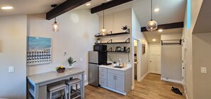 Una cocina moderna con una isla central, electrodomésticos integrados e iluminación colgante.