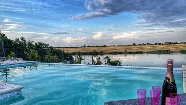Una piscina con vista a un campo y un cielo nublado.
