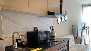 Une cuisine moderne dotée d’un îlot central, d’appareils électroménagers en acier inoxydable et d’un four encastré.