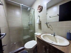 Een douche, handdoeken, zeep, toiletpapier