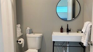 A compact bathroom with a toilet, bidet, and sink. - Modern 1-bedroom cottage in historic downtown Mount Vernon. (Mount Vernon)