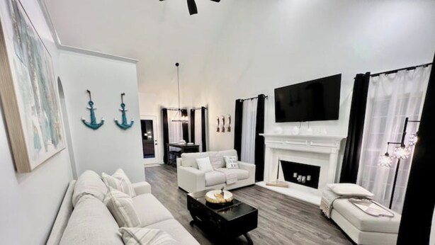 Una sala de estar moderna con un sofá blanco, una mesa de centro negra y una chimenea.