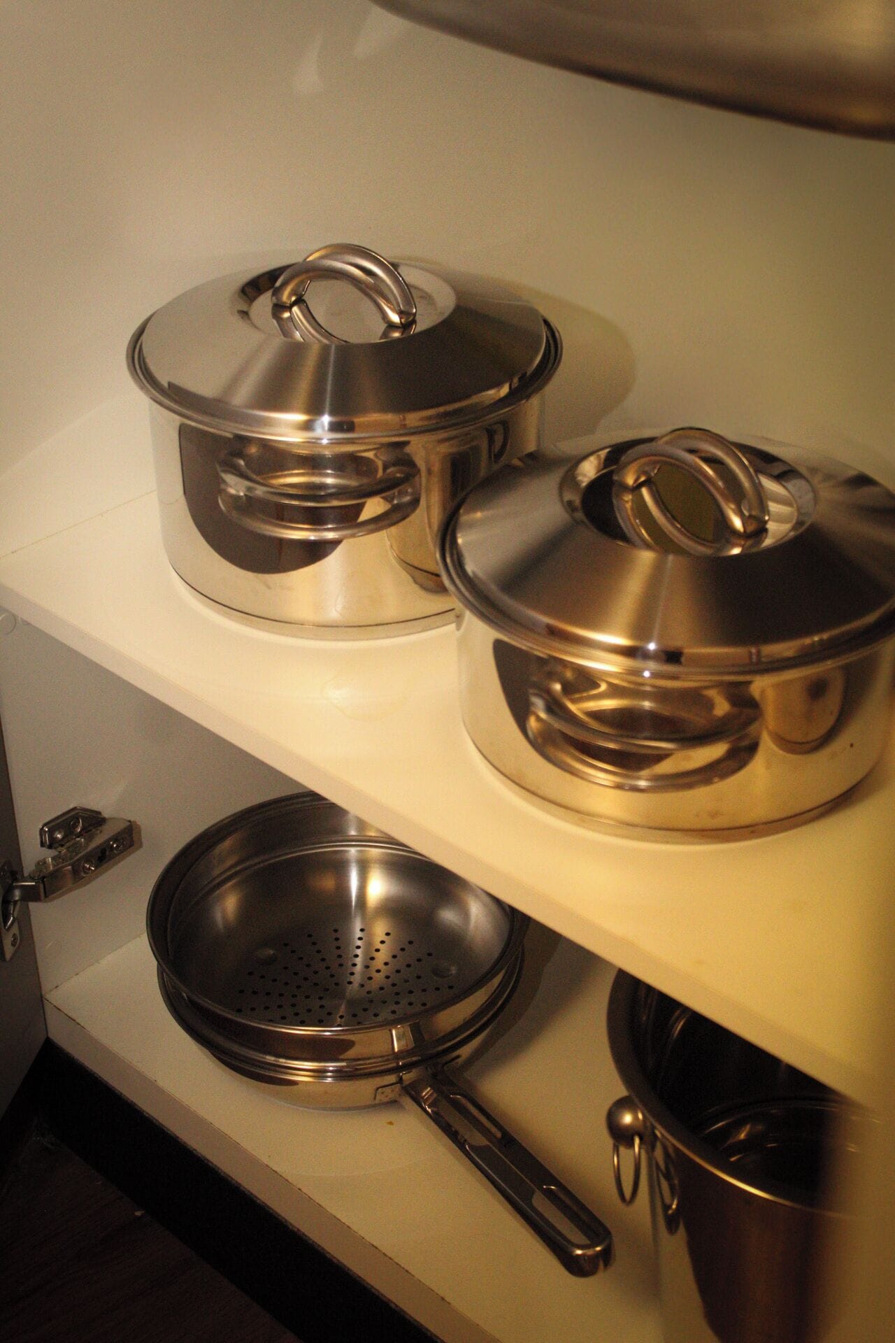Una cocina con utensilios de acero inoxidable en estantes.
