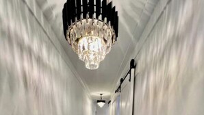 A hallway with a chandelier, wooden flooring, and white walls. - Luxury City Loft in Gainesville B (Gainesville)