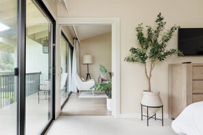 A hotel room with a balcony, a potted plant, a TV, and a bed. - Napa Golf Course Condo - 2 King Suites + En-Suite Baths - Perfect for 2 couples (Napa)