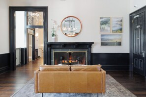 A living room with a fireplace, a sofa, and a hallway leading to another room. - Napa Golf Course Condo - 2 King Suites + En-Suite Baths - Perfect for 2 couples (Napa)