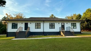 A two-story white building with black trim, featuring a central staircase and two side staircases. - Luxury City Loft in Gainesville D (Gainesville)