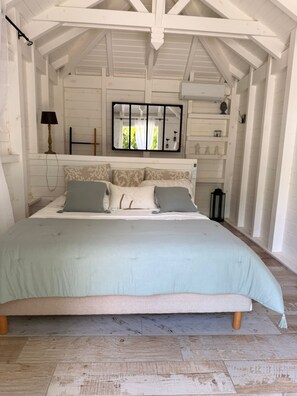 A bedroom with a large bed, a mirror, and a wooden ceiling structure. - Villa Cava, a peace of heaven with swimming pool in the heart of Baie-Mahault (Baie-Mahault)