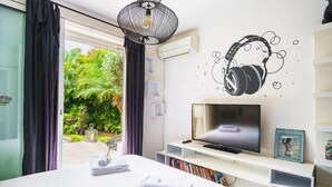 Ett hotellrum med en säng, en tv och en bokhylla.