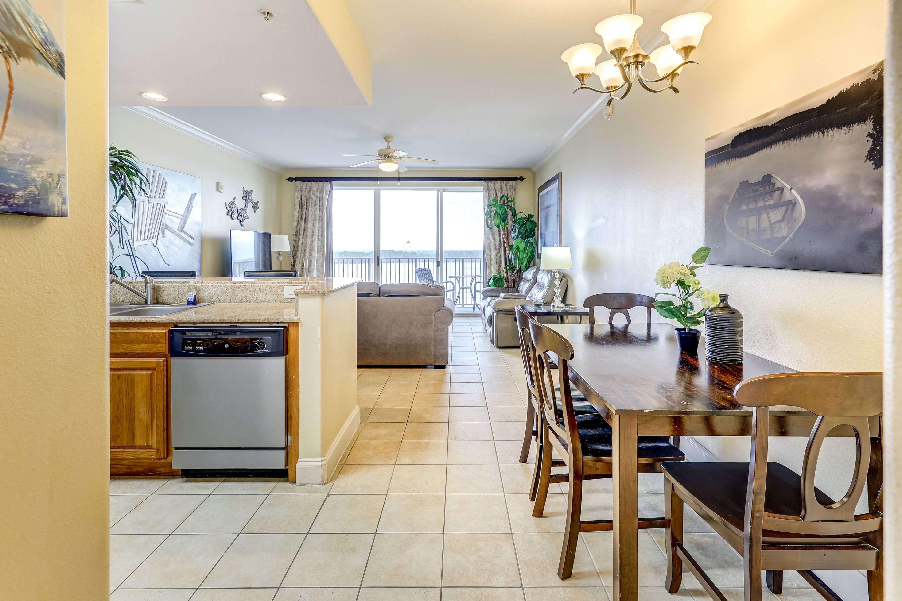 A spacious living area with a dining table, chairs, and a kitchen area with a dishwasher.