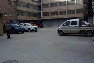 Un estacionamiento con una camioneta pickup blanca y varios automóviles.