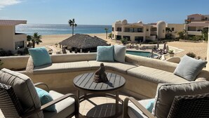 A beachside lounge with a pool, outdoor seating, and a view of the ocean. - Remodeled 2025 Beachfront Escape – Pool, Views & Walkability (Cabo San Lucas)