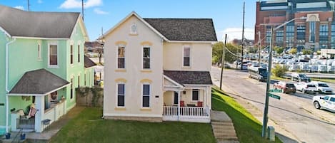A two-story house with a front porch and a small lawn.
