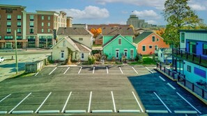 A parking lot with a row of colorful buildings in the background, including a hotel with a sign that reads "Townplace Suites."