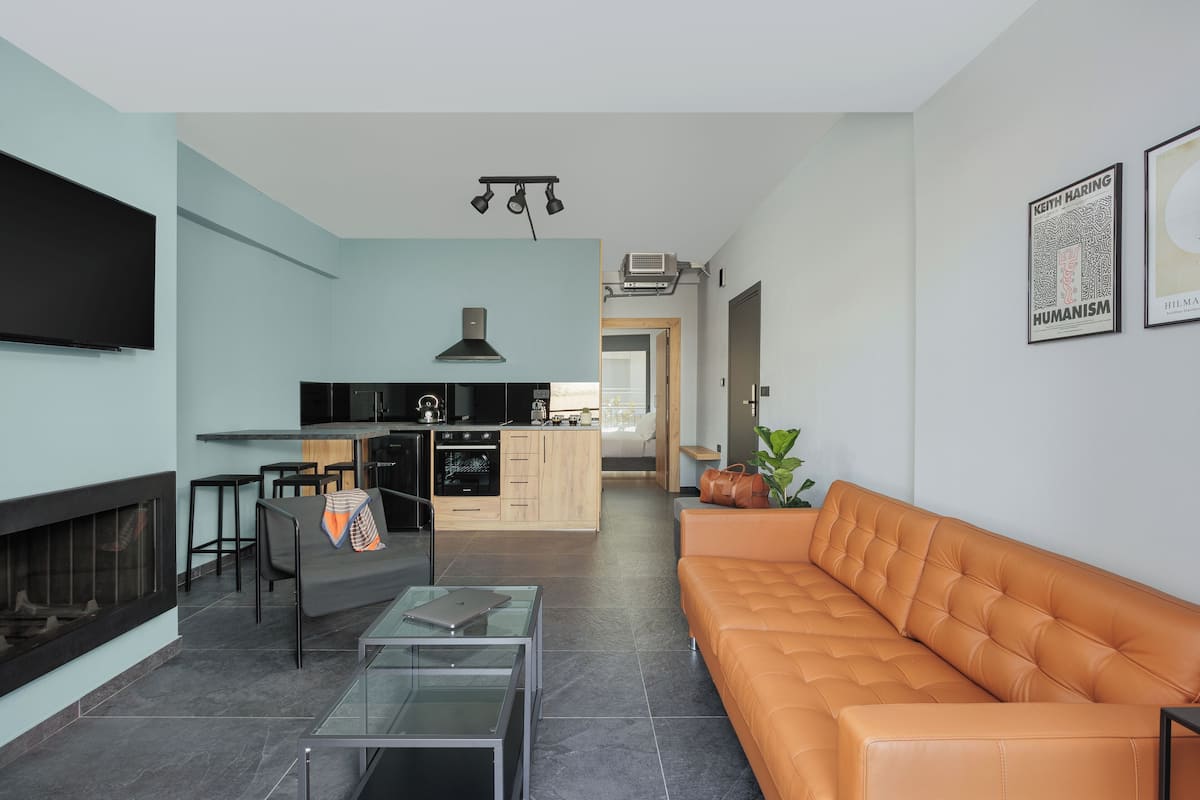 Ein modernes Wohnzimmer mit einer Couch, einem Glastisch und einem Kamin.