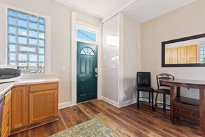 A kitchen with wooden cabinets, a microwave, and a window.
