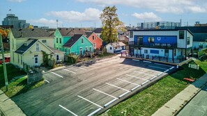 A parking lot with colorful houses in the background.