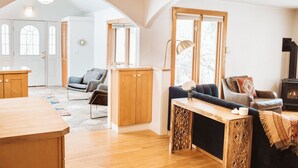 A spacious living area with a wooden dining table, a sofa, and a fireplace. - Historic 8th Ave Home - 5 BDRM Downtown Bozeman (Bozeman)