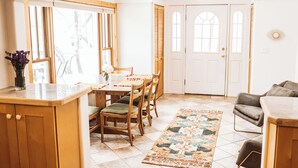 A bright kitchen with wooden cabinets, a dining table with chairs, and a rug on the floor. - Historic 8th Ave Home - 5 BDRM Downtown Bozeman (Bozeman)