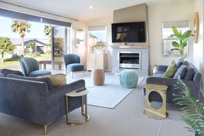 Relax in this stylish living room with a large flat-screen TV, comfortable seating, and a fireplace. Enjoy the view from the balcony.