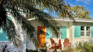 A house with a front porch, a potted plant, and a bird sculpture. - Boomerang Bungalow - Cozy, quiet retreat on Saint Augustine's Anastasia Island!  (St. Augustine)