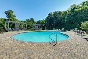 A swimming pool with a brick patio, lounge chairs, and a pergola. - Village 37 Stone Cabin with Private Hot Tub (Bryson City)