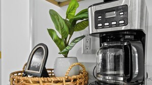 A modern kitchen with a coffee maker, a basket with a decorative item, and a potted plant. - Incredible 4-bedroom home in Tequesta FL with AC, WiFi and absolute comfort. (Tequesta)
