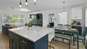 A modern kitchen with a central island, dining area, and built-in appliances. - Incredible 4-bedroom home in Tequesta FL with AC, WiFi and absolute comfort. (Tequesta)