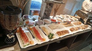 Un buffet proposant divers plats et un mixeur étiqueté « SECTION DES ALIMENTS FROIDS ».
