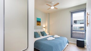 A modern bedroom with a bed, a ceiling fan, a window, and a small stool. - Home2Book Modern Bright Apt Abades, Pool & Terrace (Abades)