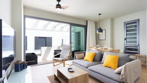 A modern living room with a grey sofa, yellow cushions, a wooden coffee table, and a ceiling fan. - Home2Book Modern Bright Apt Abades, Pool & Terrace (Abades)
